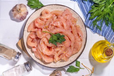 Diyet beyaz kümes hayvanlarını pişirmek. Taze dilimlenmiş tavuk şeritleri pişirmek için, baharatlar, otlar, beyaz fayansların arka planında fotokopi alanı