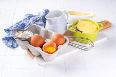 Malzemeli ev yapımı krema. Vanilya, süt ve yumurta. Tatlı krema beyaz mutfak masasının fotokopi masasında tatlı pişirme arkaplanı. 