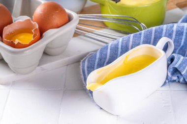 Malzemeli ev yapımı krema. Vanilya, süt ve yumurta. Tatlı krema beyaz mutfak masasının fotokopi masasında tatlı pişirme arkaplanı. 