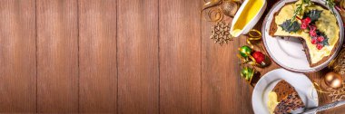Geleneksel Noel İngiliz pudingi tatlısı. Kremalı kremalı ev yapımı meyveli puding. Noel için tatlı aromalı meyveli pasta, yeni yıl yemeği, süslü arka planda.