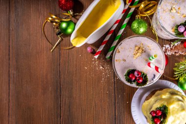 Noel pudingi ya da milkshake. Kremalı kremalı kremalı tatlı aromalı smoothie, İngiliz pudingli pasta parçacıkları, kurutulmuş meyveler, samimi Noel dekorasyonlu arka plan