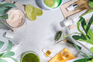 Doğa Yaşlanma Karşıtı Kozmetik, Terapi Masajı. Asya güzellik bakımı. Yeşim silindir, gua sha masaj aleti çeşitli organik serumlar, jel, bitkisel özler, spa havluları. Beyaz mermer arka planda düz alan