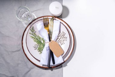 Noel, yeni yıl, Şükran Günü kış tatili sofrası. Tatil yemeği için. Tabak, çatal bıçak, peçete, cam, mum ve hediye kutularıyla süslü bir masa..