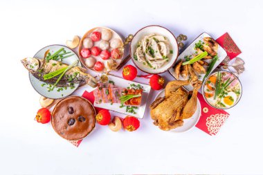 Geleneksel Çin Yeni Yıl yemeği masası, parti davetiyesi, menü geçmişi domuz eti, kızarmış balık, tavuk, pirinç köftesi, mantı, fal kurabiyesi, nian gao keki, erişte, Çin dekorasyonu.