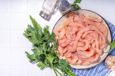 Diyet beyaz kümes hayvanlarını pişirmek. Taze dilimlenmiş tavuk şeritleri pişirmek için, baharatlar, otlar, beyaz fayansların arka planında fotokopi alanı