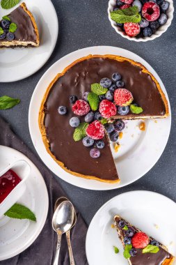 Çikolata ve çilekli ev yapımı cheesecake. Tatlı süzme peynirli pasta, taze ve çikolata soslu klasik tatlı, siyah beton masa fotokopisi alanı.