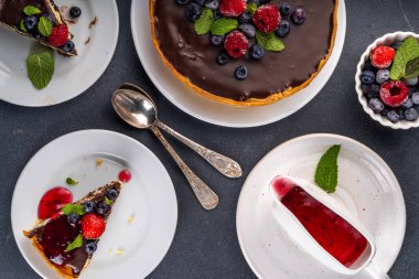 Çikolata ve çilekli ev yapımı cheesecake. Tatlı süzme peynirli pasta, taze ve çikolata soslu klasik tatlı, siyah beton masa fotokopisi alanı.