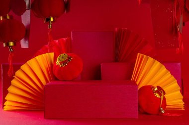 Çin 'in yeni yıl arkaplanı, ürün kaidesi podyumu sergisi, renkli Çin fenerleri, kağıt fanları ve parlak kırmızı arka plan fotokopi alanındaki dilekler için geleneksel Yeni Yıl çizgileri posterleri.