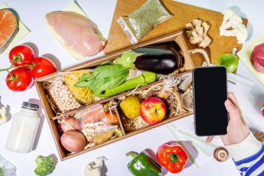 Yemek seti teslimat konsepti. Çeşitli sağlıklı yemek malzemeleri koyun et, sebze, meyve, baharat ve yemek tarifleri. İnternetten şef malzemeleri sipariş etmek, market teslimatı.