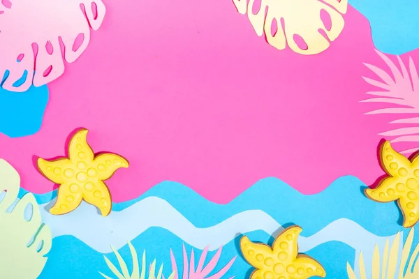 Summer trendy colorful background. Paper art minimal background with various bright paper tropical leaves, ocean sea waves, shells and starfish. Creative summertime holiday vacation background