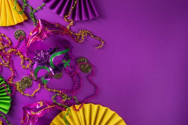 Mardi Gras renkli bayram tebrik kartı arkaplanı festival maskesi, dekor, karnaval maskesi, boncuklar, tüyler, parlak arka plandaki fanlar geleneksel mor yeşil renkler