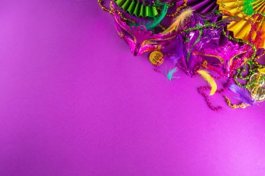 Mardi Gras renkli bayram tebrik kartı arkaplanı festival maskesi, dekor, karnaval maskesi, boncuklar, tüyler, parlak arka plandaki fanlar geleneksel mor yeşil renkler
