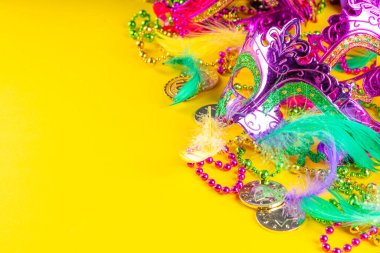 Mardi Gras renkli bayram tebrik kartı arkaplanı festival maskesi, dekor, karnaval maskesi, boncuklar, tüyler, parlak arka plandaki fanlar geleneksel mor yeşil renkler