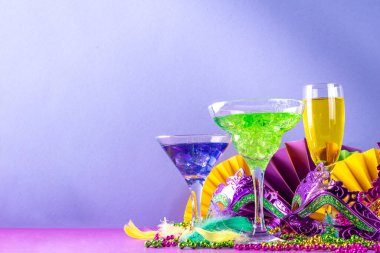Mardi Gras kokteylleri hazır. Renkli mor, sarı, yeşil martini şampanya Mardi Gras parti barı için şarap bardakları karnaval dekorlu ve Orleans maskeli
