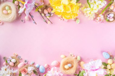 Spring Easter holiday top view flat lay background with eggs in nests and flowers. Happy Easter  greeting card background with copy space, on pastel pink background copy space