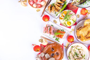 Geleneksel Çin Yeni Yıl yemeği masası, parti davetiyesi, menü geçmişi domuz eti, kızarmış balık, tavuk, pirinç köftesi, mantı, fal kurabiyesi, nian gao keki, erişte, Çin dekorasyonu.