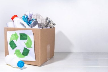 Çöp ayıklama, atık geri dönüşüm konsepti. Geri dönüşüm malzemelerinin olduğu kutu - plastik, cam, kağıt, karton, beyaz ahşap arka plan fotokopi alanı. Kadın elleri çeşitli çöp ve çöpleri ayırıyor.