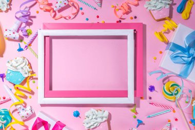 Mutlu yıllar tebrik kartı geçmişi. Renkli tatil aletleri olan düz yatak - doğum günü partisi şapkaları, şişirme makineleri, hediye kutuları, balonlar, buharlı mumlar, pembe arka plan fotokopi alanı