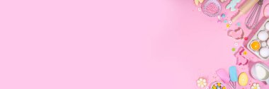 Cute pink sweet baking flat lay for Easter holiday. Cooking background with baking ingredients, rolling pin, whisk for whipping, cookie and cutters, sugar sprinkling, flour, top view copy space 