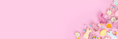 Cute pink sweet baking flat lay for Easter holiday. Cooking background with baking ingredients, rolling pin, whisk for whipping, cookie and cutters, sugar sprinkling, flour, top view copy space 