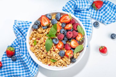 Healthy breakfast granola with fresh berry - strawberry, raspberry, blueberry on white background