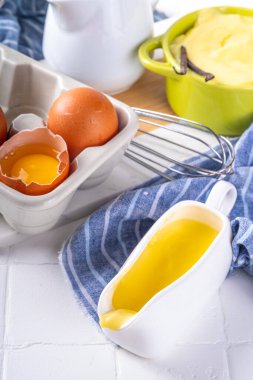 Malzemeli ev yapımı krema. Vanilya, süt ve yumurta. Tatlı krema beyaz mutfak masasının fotokopi masasında tatlı pişirme arkaplanı. 