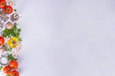 Cooking background with vegetable ingredients. Healthy dinner preparation flat lay, with fresh raw tomatoes, onion, garlic, herbs and greens, olive oil, salt, pepper seasonings, on white background 