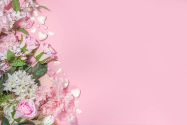 Pembe ve beyaz bahar tatili arka planında çeşitli tatlı çiçekler var. Sevgililer günü, uluslararası kadınlar günü 8 Mart, doğum günü, anneler günü tebrik kartı üst görünüm düz çerçeve