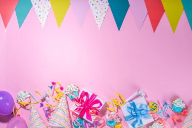 Mutlu yıllar tebrik kartı geçmişi. Renkli tatil aletleri olan düz yatak - doğum günü partisi şapkaları, şişirme makineleri, hediye kutuları, balonlar, buharlı mumlar, pembe arka plan fotokopi alanı