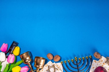 Passover, Pesah background. jewish Easter Passover spring holiday celebration, with accessories - menorah, matzo, spring flowers, wine bottle, gold wine glass, jewish david stars