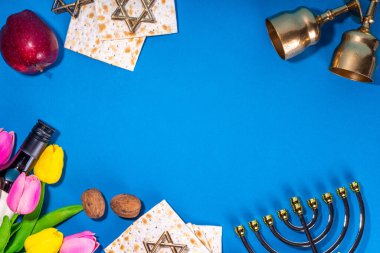 Passover, Pesah background. jewish Easter Passover spring holiday celebration, with accessories - menorah, matzo, spring flowers, wine bottle, gold wine glass, jewish david stars