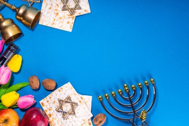 Passover, Pesah background. jewish Easter Passover spring holiday celebration, with accessories - menorah, matzo, spring flowers, wine bottle, gold wine glass, jewish david stars