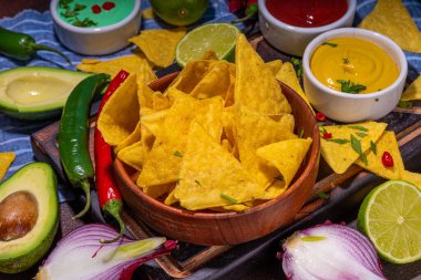 Traditional Mexican street food, fast food background, corn Taco, nachos with meat, vegetables, avocado, beans, corn, salsa. Served with various sauces. Mexican holiday flatlay