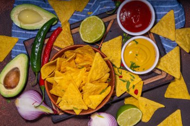 Traditional Mexican street food, fast food background, corn Taco, nachos with meat, vegetables, avocado, beans, corn, salsa. Served with various sauces. Mexican holiday flatlay
