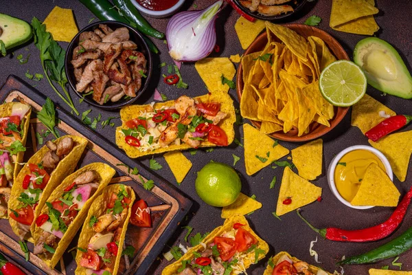 Traditional Mexican street food, fast food background, corn Taco, nachos with meat, vegetables, avocado, beans, corn, salsa. Served with various sauces. Mexican holiday flatlay