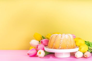 Easter sweets and candies background. High-colored blue flat lay with various Easter chocolate eggs, treats, symbols of easter sheep, bunny, carrot, flowers, cookies, top view copy space, frame