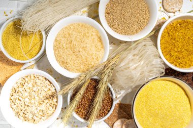 Selection of whole grains gluten free cereals. Set of various non-gluten cereals: rice, buckwheat, corn groats, quinoa, millet, oats, buckwheat, bulgur, porridge, barley, white background copy space