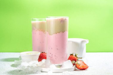 Doğal sağlıklı yaz içeceği. Diyet organik çilek ve matcha latte kokteyli, taze çilek ve buzlu, açık yeşil arka planda.