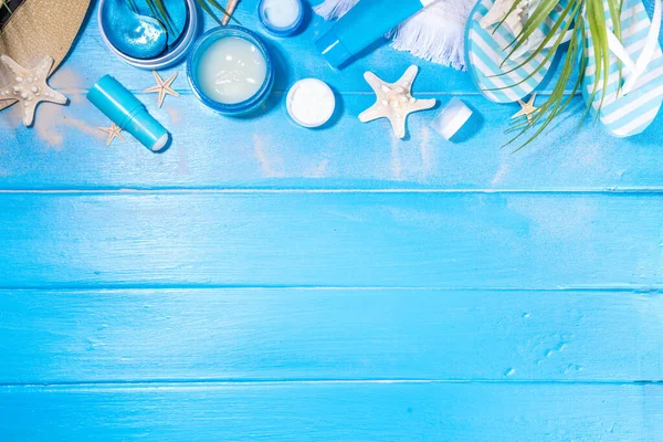 stock image Summer skin care cosmetics set. Different jars, tubes of sunscreen moisturizer, cream, serum, masks, cosmetics for face and hands, on summer sea beach blue wooden background, accessorizes, seashells