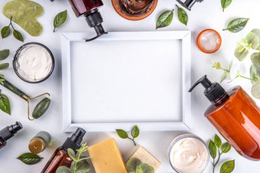 Natural organic skin care flat lay. Natural organic beauty cosmetic products on white background: hand lotion, face cream in jar, essential oil, skin roller, with eucalyptus and tea tree leaves clipart