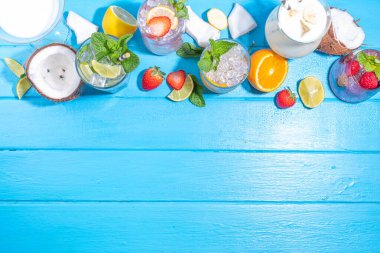 Summer cocktails drinks. Classic alcoholic long drink mocktail versions, various beverages, lemonades with berries, lime, orange, coconut, ice on light blue sunny sea beach bar background 