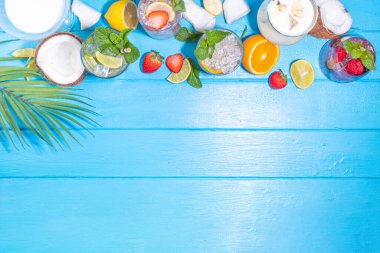 Summer cocktails drinks. Classic alcoholic long drink mocktail versions, various beverages, lemonades with berries, lime, orange, coconut, ice on light blue sunny sea beach bar background 