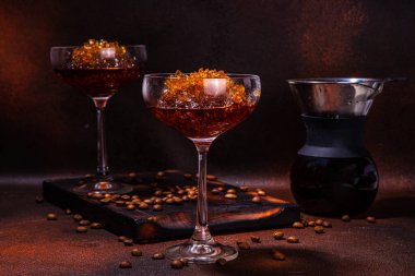 Martini bardağında espresso kahveli buzlu kokteyl, kahve makinesi damlatıyor. Koyu kahverengi arka plan fotokopi alanı üzerine sert kahve granitası. 