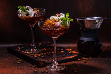 Martini bardağında espresso kahveli buzlu kokteyl, kahve makinesi damlatıyor. Koyu kahverengi arka plan fotokopi alanı üzerine sert kahve granitası.