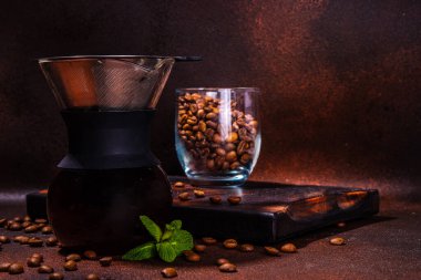 Chemex el yapımı kahve makinesi, yavaş ve damlatan espresso kahve makinesi, kahve çekirdekleri ve koyu kahverengi arka plan fotokopi alanı.