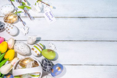  Paskalya Bayramı tebrik kartı geçmişi. Söğüt çiçeği dalları, renkli yeşil, sepetteki altın Paskalya yumurtaları, beyaz ahşap arka planda Mutlu Paskalyalar kopya alanı
