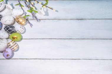  Paskalya Bayramı tebrik kartı geçmişi. Söğüt çiçeği dalları, renkli yeşil, sepetteki altın Paskalya yumurtaları, beyaz ahşap arka planda Mutlu Paskalyalar kopya alanı