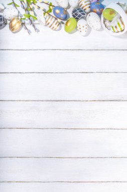  Paskalya Bayramı tebrik kartı geçmişi. Söğüt çiçeği dalları, renkli yeşil, sepetteki altın Paskalya yumurtaları, beyaz ahşap arka planda Mutlu Paskalyalar kopya alanı