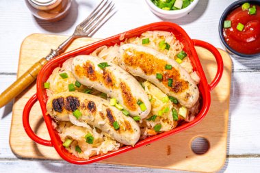 Kızarmış Münih usulü sosis, kızarmış lahana ya da lahana turşusu. Oktoberfest, Bavyera yaz barbeküsü parti yemeği porsiyonu, taze otlar ve domates sosu.