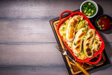 Kızarmış Münih usulü sosis, kızarmış lahana ya da lahana turşusu. Oktoberfest, Bavyera yaz barbeküsü parti yemeği porsiyonu, taze otlar ve domates sosu.